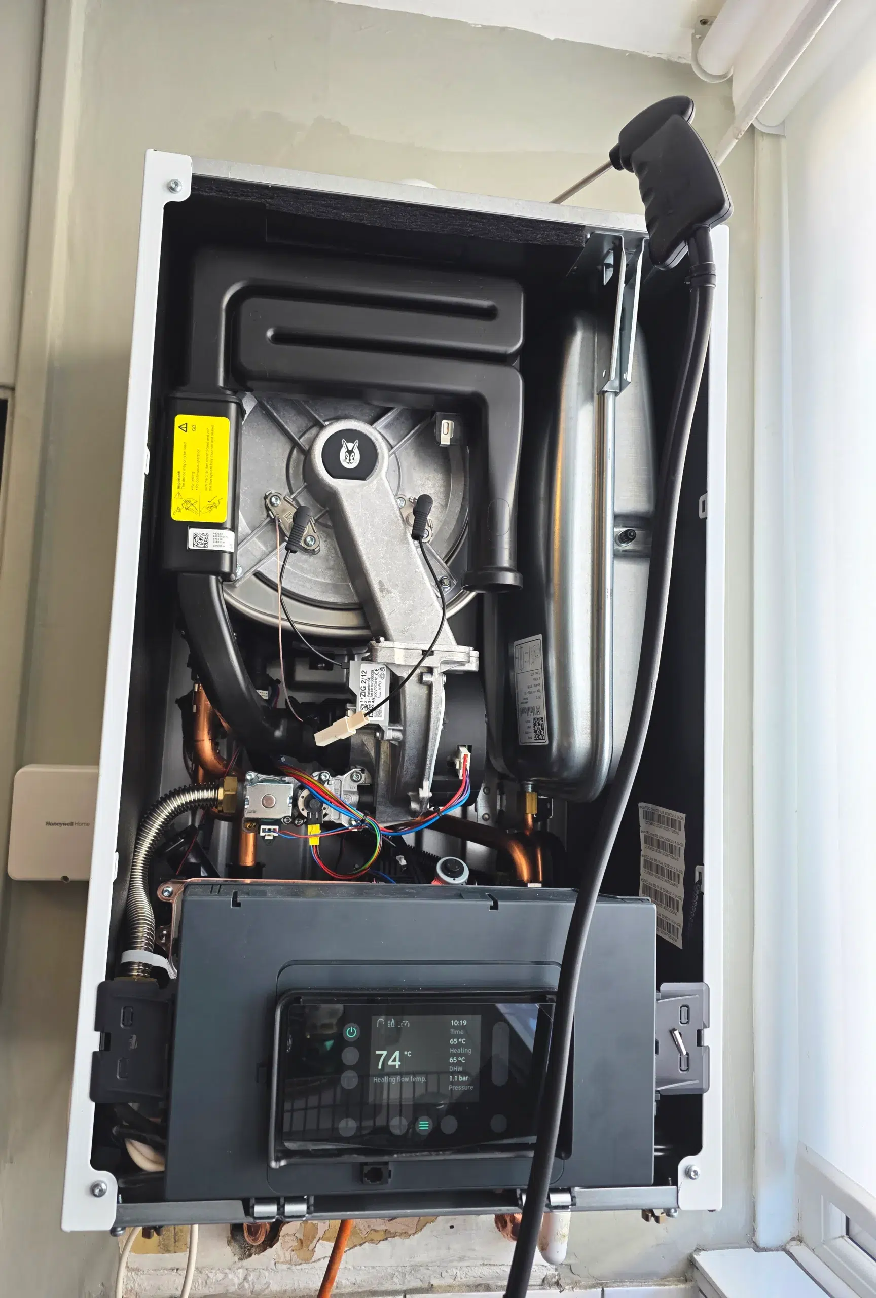 Gas engineer carrying out boiler inspection for home buyers survey in Streatham, South West London