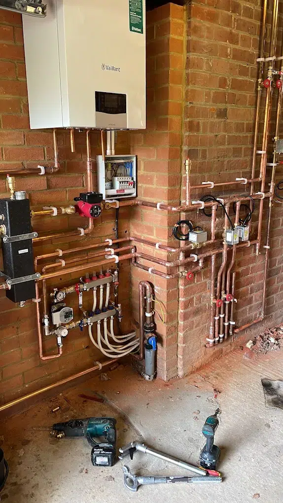 Commercial plant room heating installation in London with boiler, manifolds and copper pipework